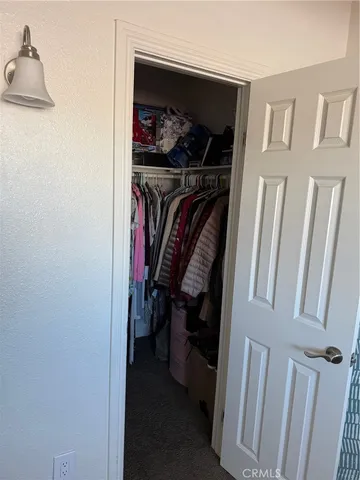a view of walk in closet with clothes and shoes