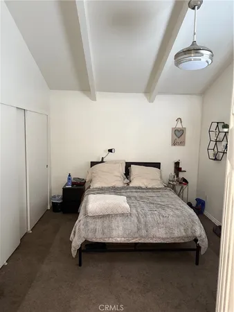 a bedroom with a bed and painting on the wall