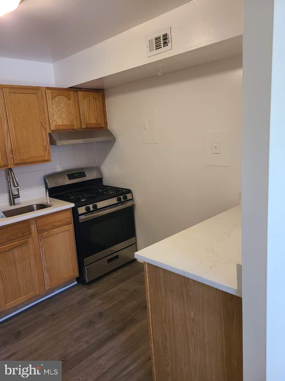 8685 Greenbelt Road, Unit 102 Greenbelt, MD 20770 - Photo 5 of 15 a kitchen with granite countertop a stove and a microwave