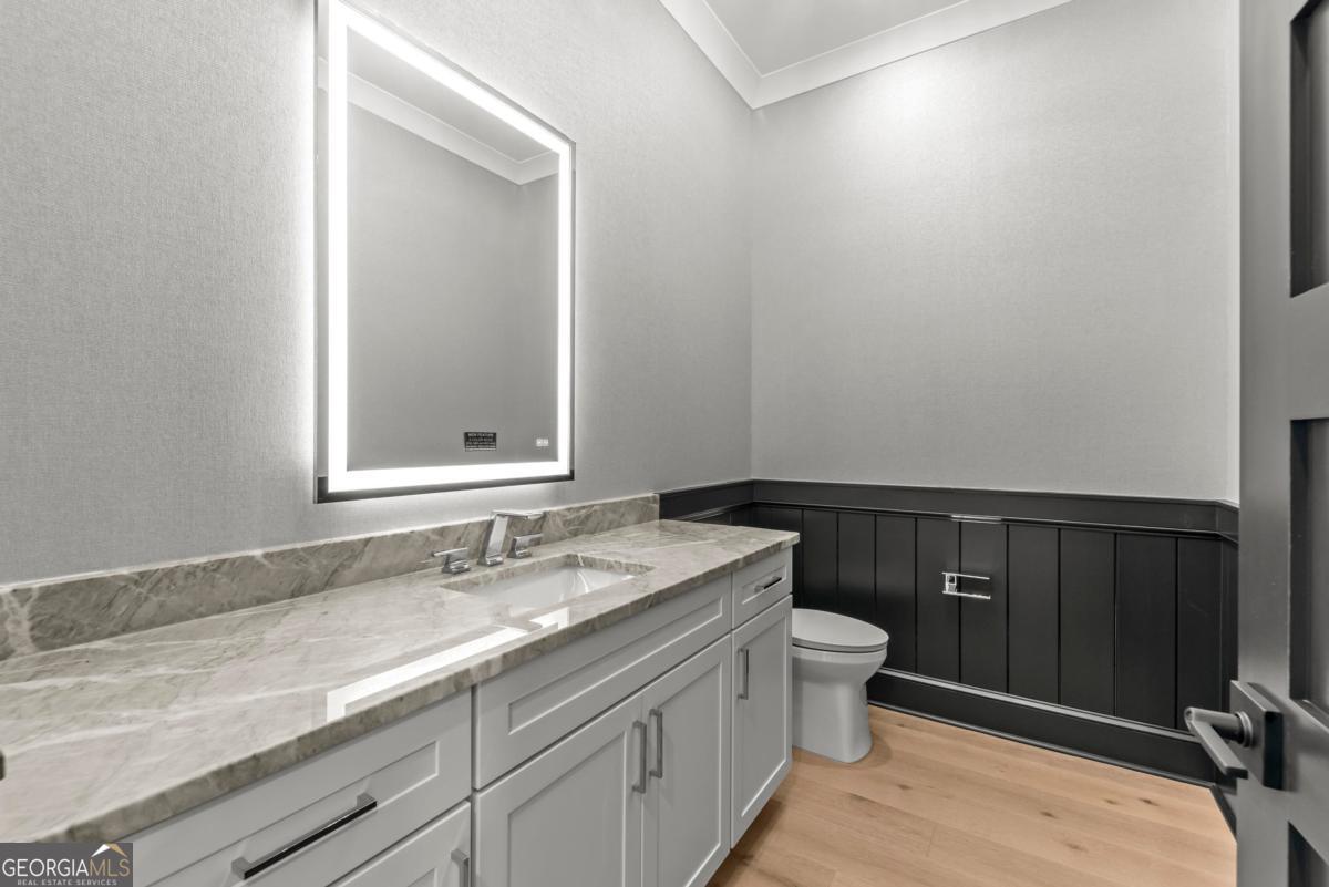 1089 B Crooked Creek Road Eatonton, GA 31024 - Photo 18 of 74 a bathroom with a granite countertop sink a toilet and a mirror