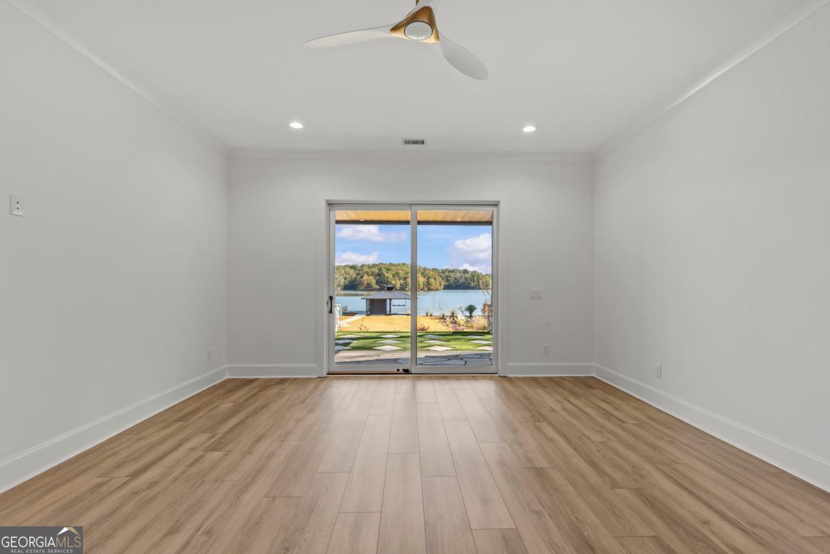 1089 B Crooked Creek Road Eatonton, GA 31024 - Photo 38 of 74 a view of an empty room with wooden floor and a window