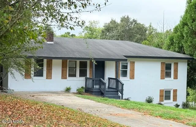 a view of a house with a patio and a yard