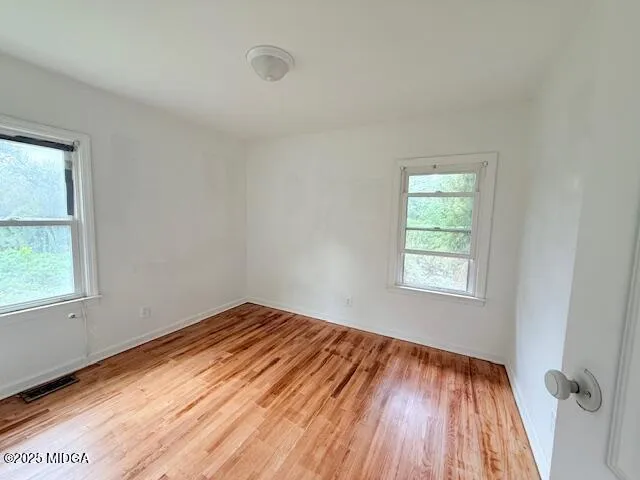 a bathroom with a toilet and a painting on the wall