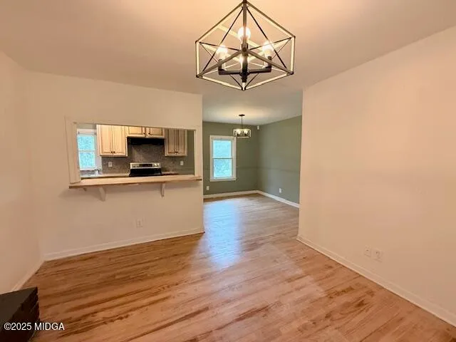 a view of a kitchen with a microwave and wooden floor
