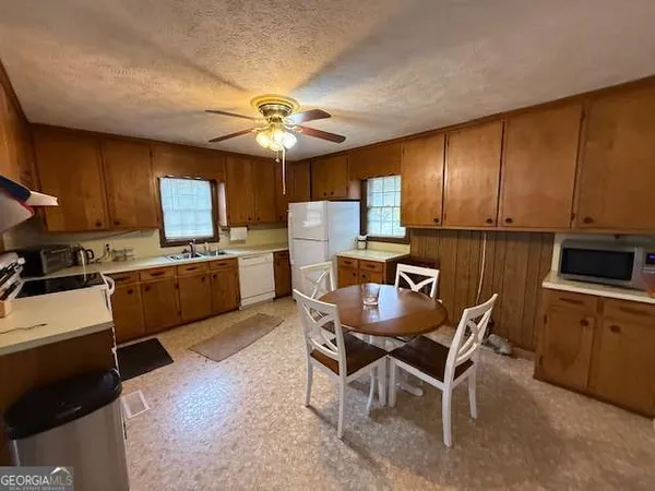 a kitchen with a dining table chairs and a refrigerator