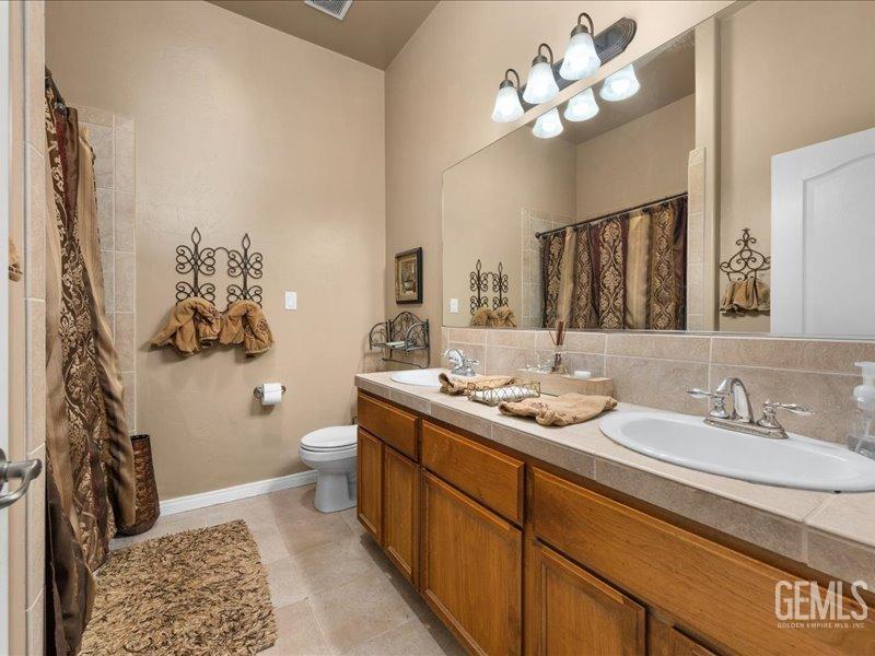 Undisclosed Address Bakersfield, CA 93314 - Photo 27 of 38 a bathroom with a double vanity sink mirror and toilet