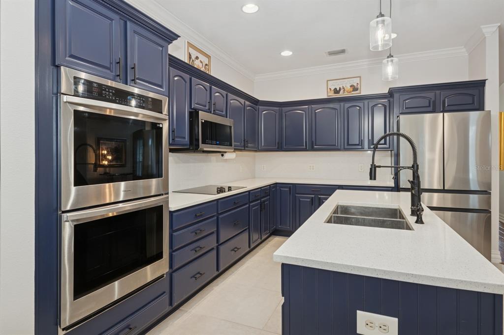 35520 Timbertop Lane Fruitland Park, FL 34731 - Photo 12 of 82 a kitchen with kitchen island a sink appliances and cabinets