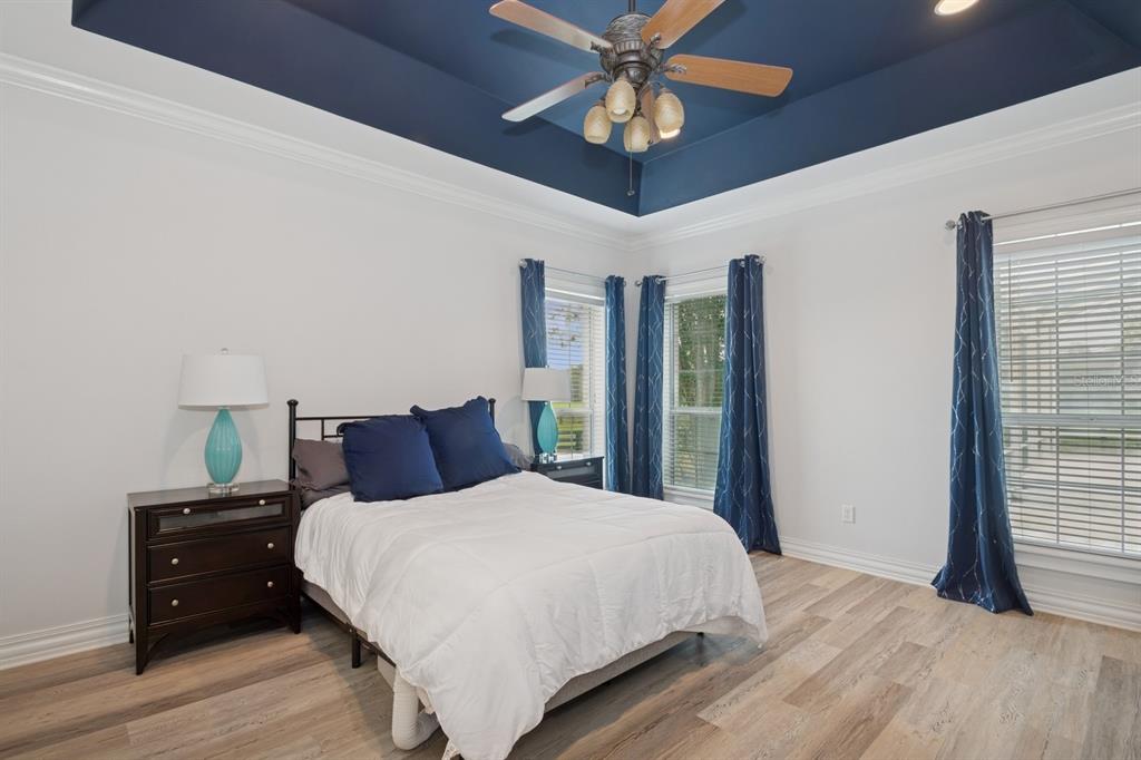 35520 Timbertop Lane Fruitland Park, FL 34731 - Photo 23 of 82 a bedroom with a large bed and a chandelier