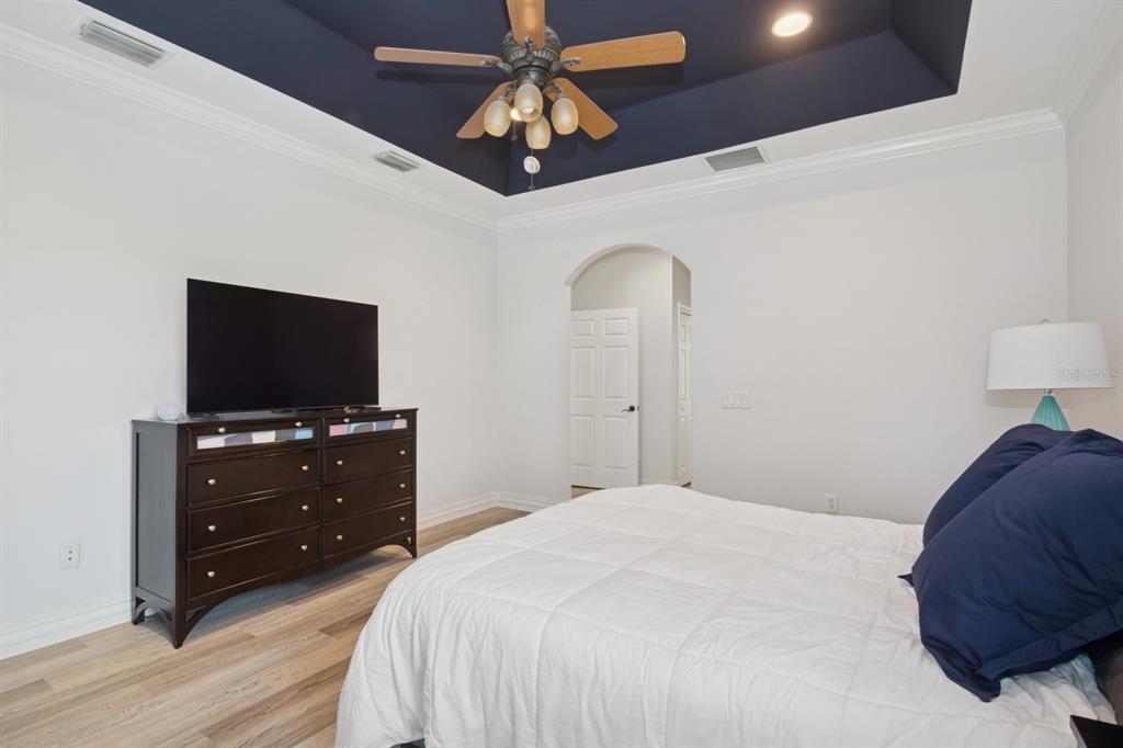 35520 Timbertop Lane Fruitland Park, FL 34731 - Photo 24 of 82 a bedroom with a bed and a flat tv screen on a dresser