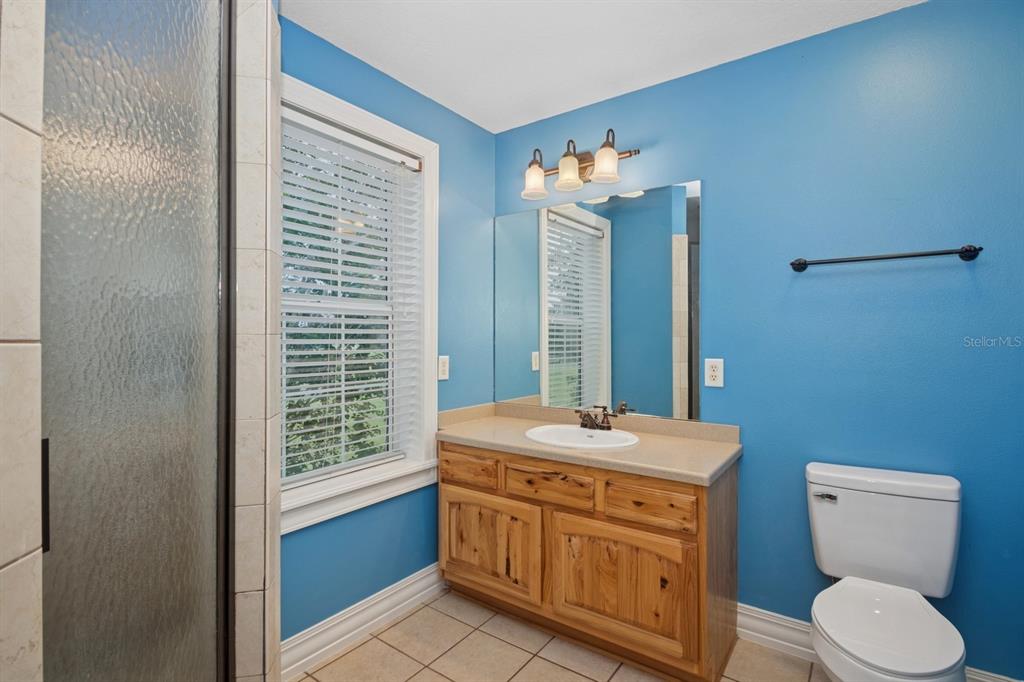 35520 Timbertop Lane Fruitland Park, FL 34731 - Photo 38 of 82 a bathroom with a granite countertop toilet a sink and a mirror