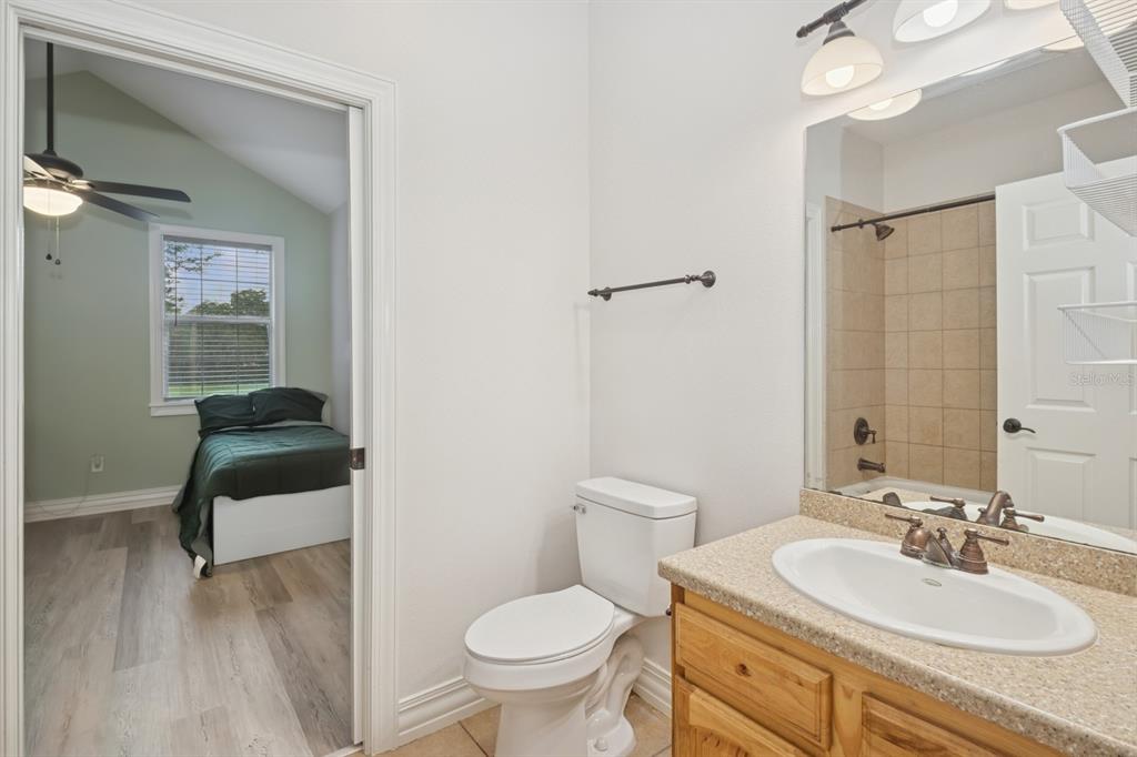35520 Timbertop Lane Fruitland Park, FL 34731 - Photo 40 of 82 a bathroom with a sink toilet a mirror and vanity