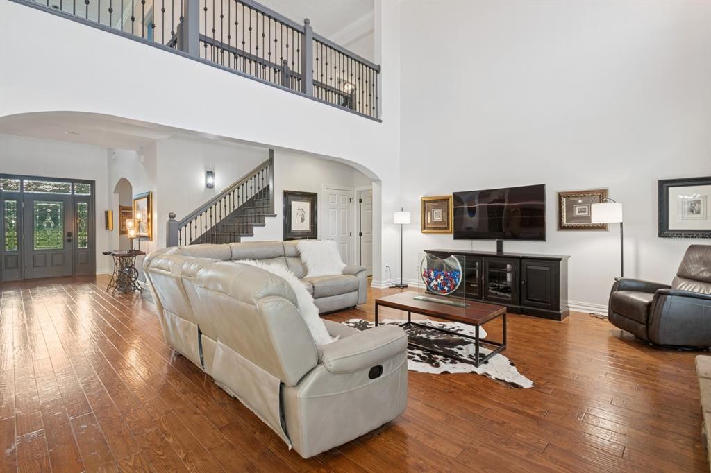 35520 Timbertop Lane Fruitland Park, FL 34731 - Photo 6 of 82 a living room with furniture a flat screen tv and wooden floor