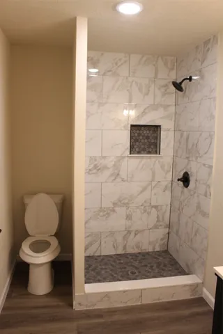 a bathroom with a toilet and a shower