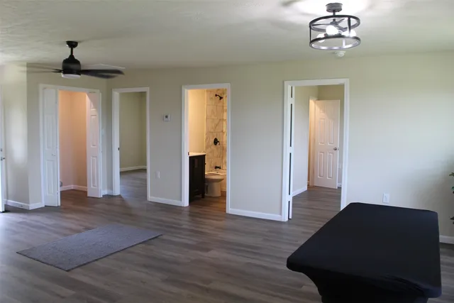 a view of a livingroom with wooden floor and a ceiling fan
