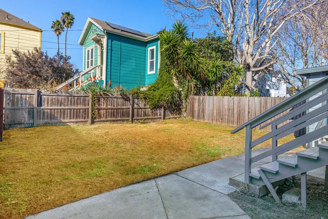 a view of a backyard with a small cabin and wooden fence