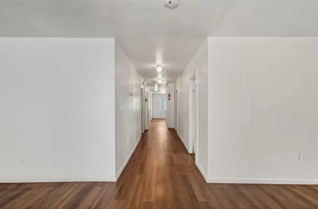 a view of a hallway with wooden floor