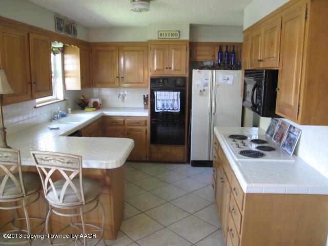 7106 Elmhurst Road Amarillo, TX 79106 - Photo 3 of 10 a kitchen with stainless steel appliances granite countertop a sink stove and refrigerator