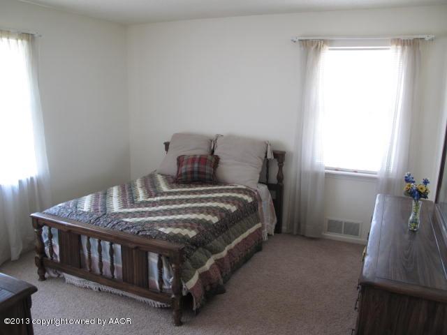7106 Elmhurst Road Amarillo, TX 79106 - Photo 8 of 10 a bedroom with a bed next to a window