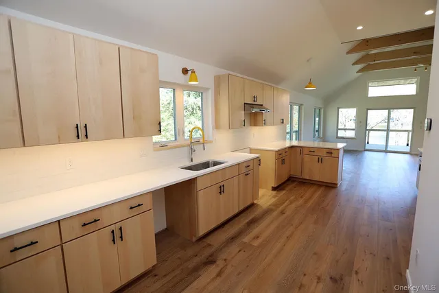 a large kitchen with a lot of counter space and wooden floor