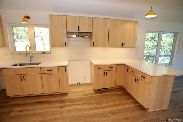 a kitchen with white cabinets and wooden floors