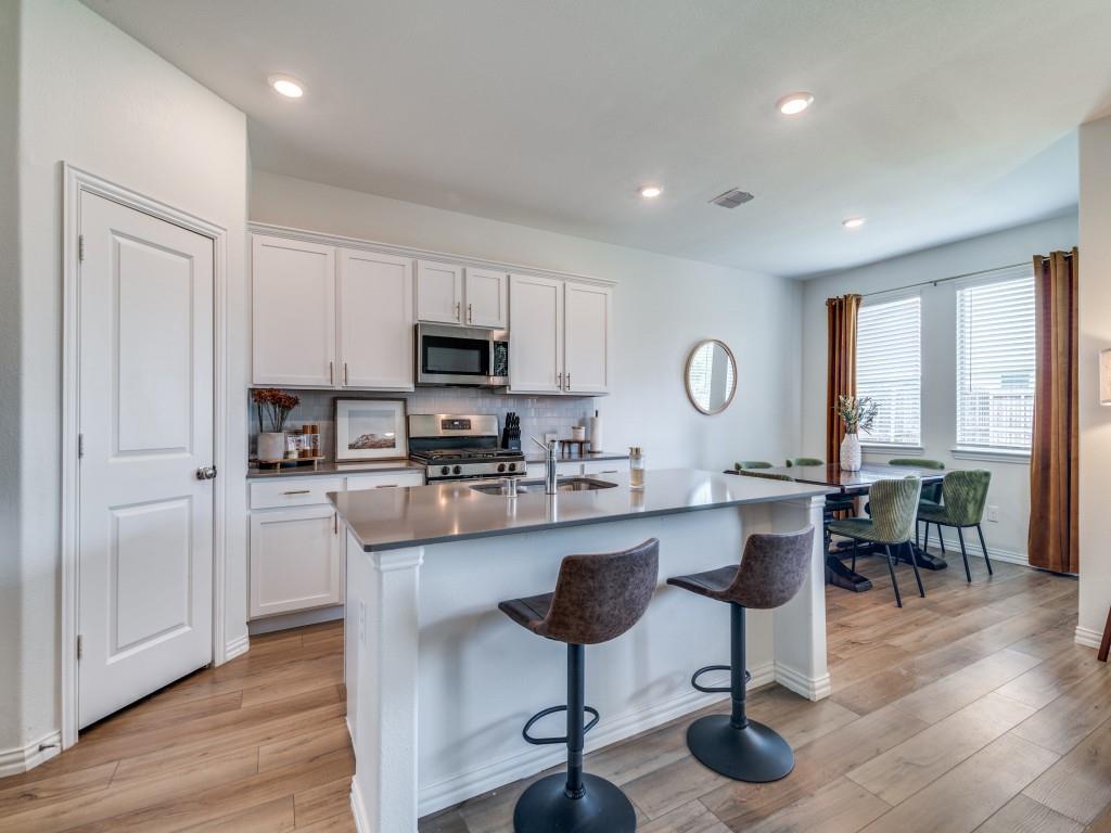 656 Beltrand Lane Fate, TX 75087 - Photo 6 of 22 Tasteful backsplash, island with bar stools, large pantry, soft close drawers and cabinets