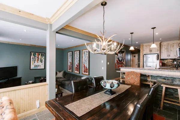 a living room with dining table furniture and a chandelier