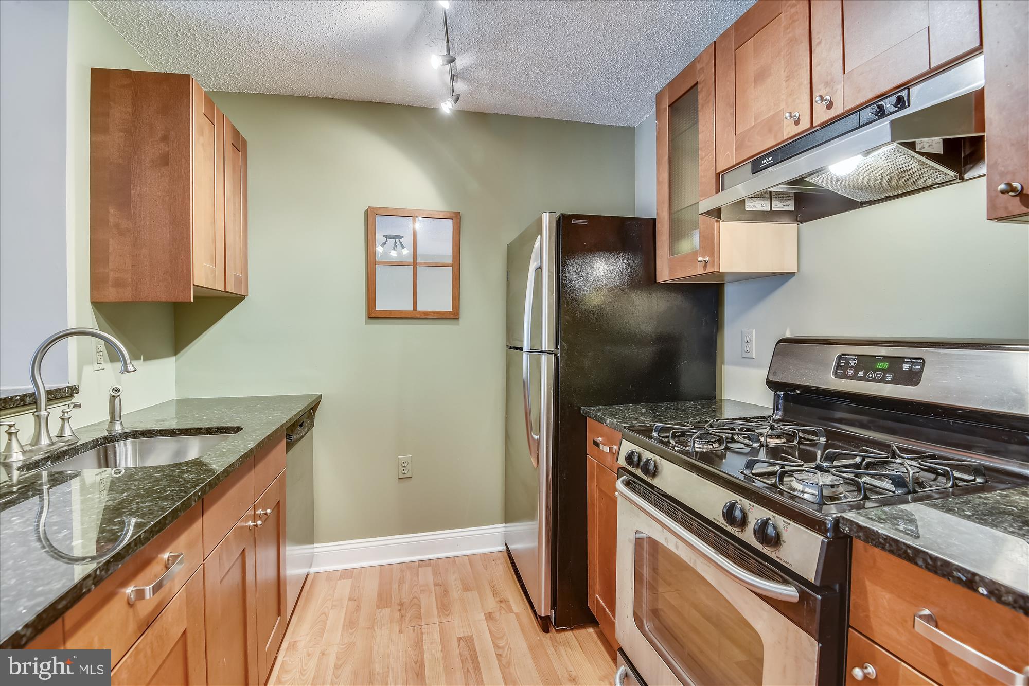 20979 Timber Ridge Terrace, Unit 204 Ashburn, VA 20147 - Photo 2 of 29 a kitchen with stainless steel appliances granite countertop a sink stove and refrigerator