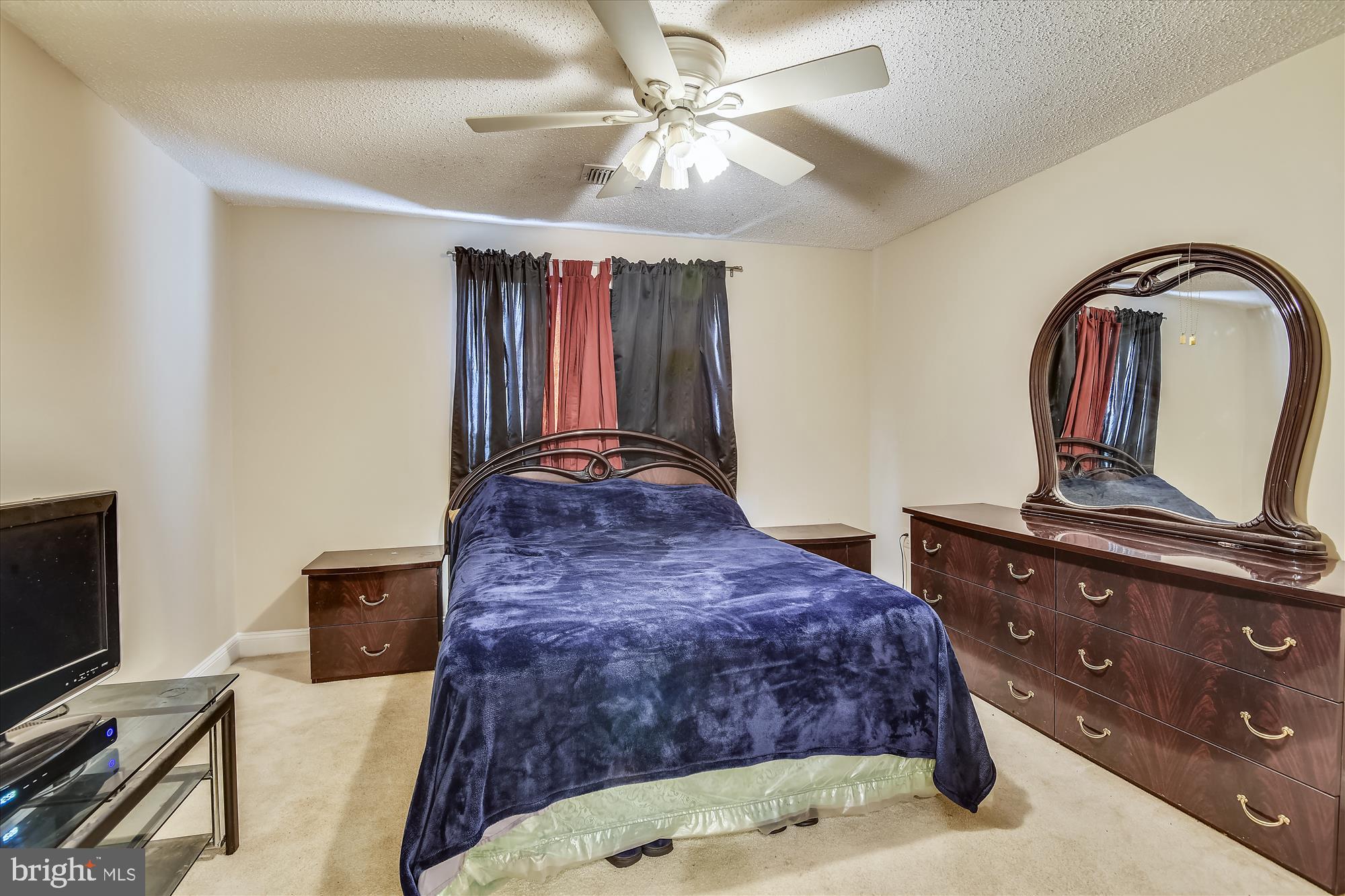 20979 Timber Ridge Terrace, Unit 204 Ashburn, VA 20147 - Photo 12 of 29 a bedroom with a bed and a flat tv screen on the dresser