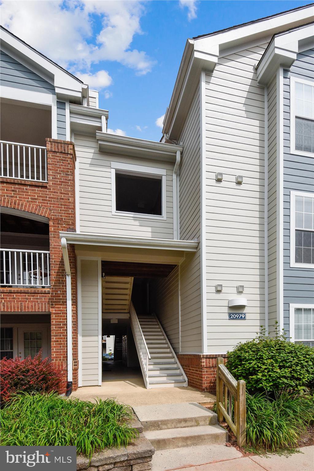 20979 Timber Ridge Terrace, Unit 204 Ashburn, VA 20147 - Photo 24 of 29 a front view of a house with a yard