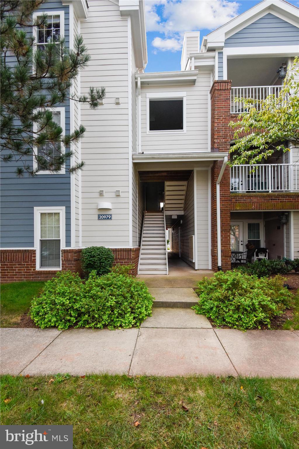 20979 Timber Ridge Terrace, Unit 204 Ashburn, VA 20147 - Photo 25 of 29 a front view of a house with garden