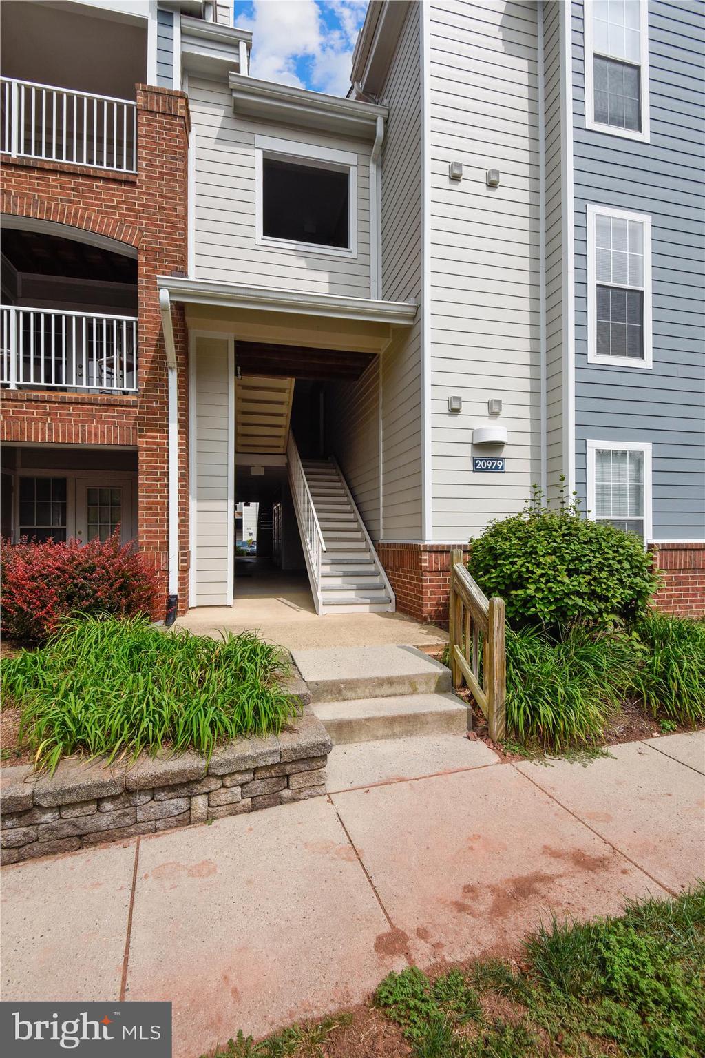 20979 Timber Ridge Terrace, Unit 204 Ashburn, VA 20147 - Photo 26 of 29 a front view of a house with a yard