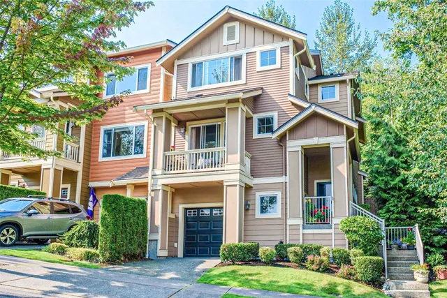a front view of a house with a yard and potted plants