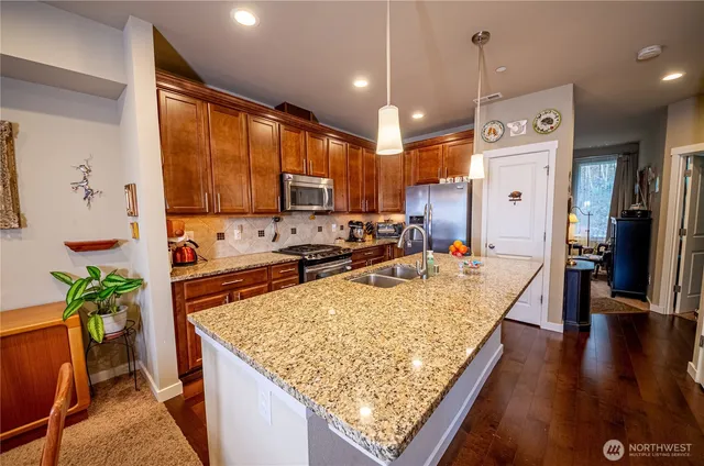 a large kitchen with kitchen island a counter space a sink a stove and refrigerator