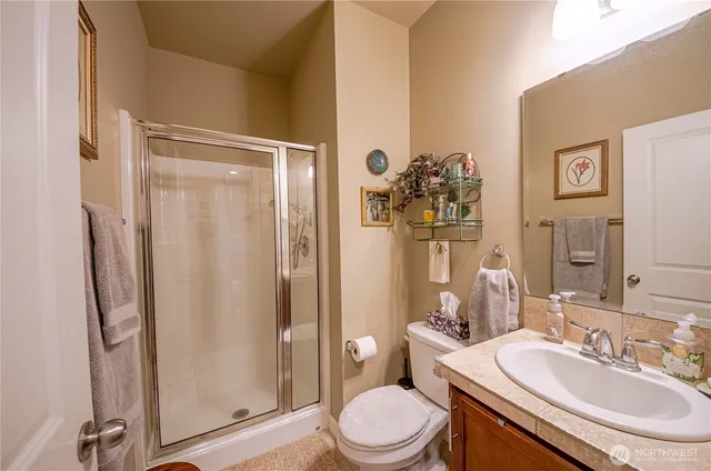 a bathroom with a granite countertop sink toilet and shower