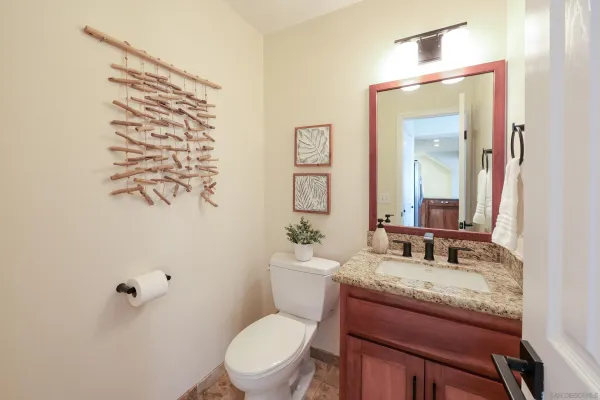 a bathroom with a granite countertop sink mirror vanity and toilet
