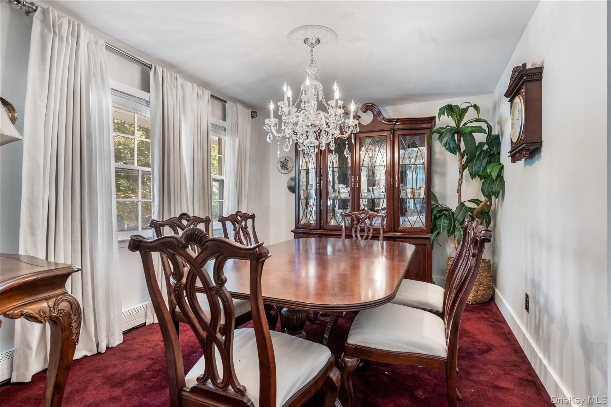 50 Propose Road Shirley, NY 11967 - Photo 2 of 12 Formal dining area featuring a crystal chandelier and plush red carpeting
