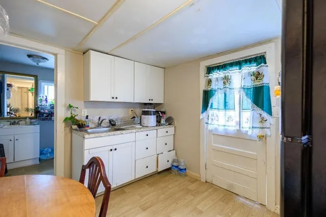 a room with a baby bed furniture and a window