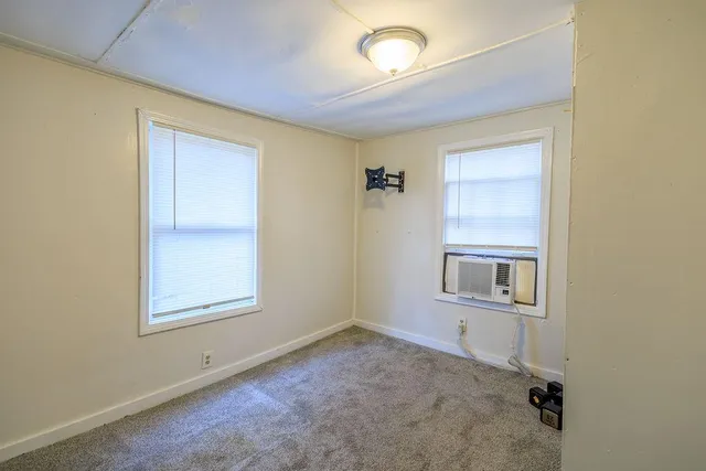 an empty room with windows and closet