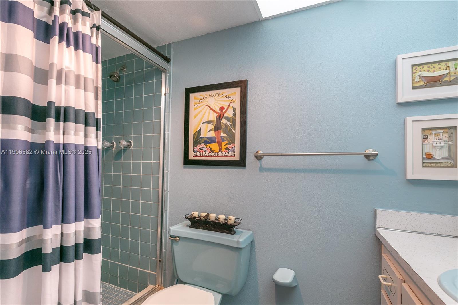 1001 Northeast 14th Avenue, Unit 107 Hallandale Beach, FL 33009 - Photo 19 of 28 a bathroom with a toilet a sink and shower curtain