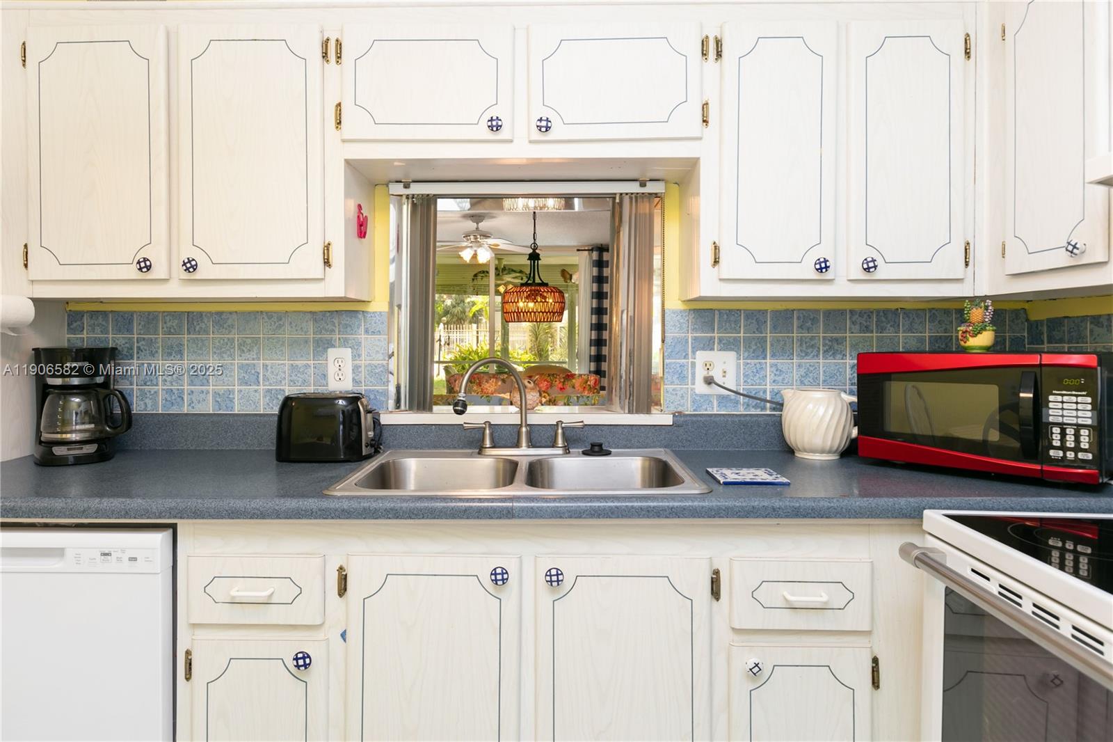 1001 Northeast 14th Avenue, Unit 107 Hallandale Beach, FL 33009 - Photo 7 of 28 a kitchen with stainless steel appliances granite countertop a sink a stove and white cabinets