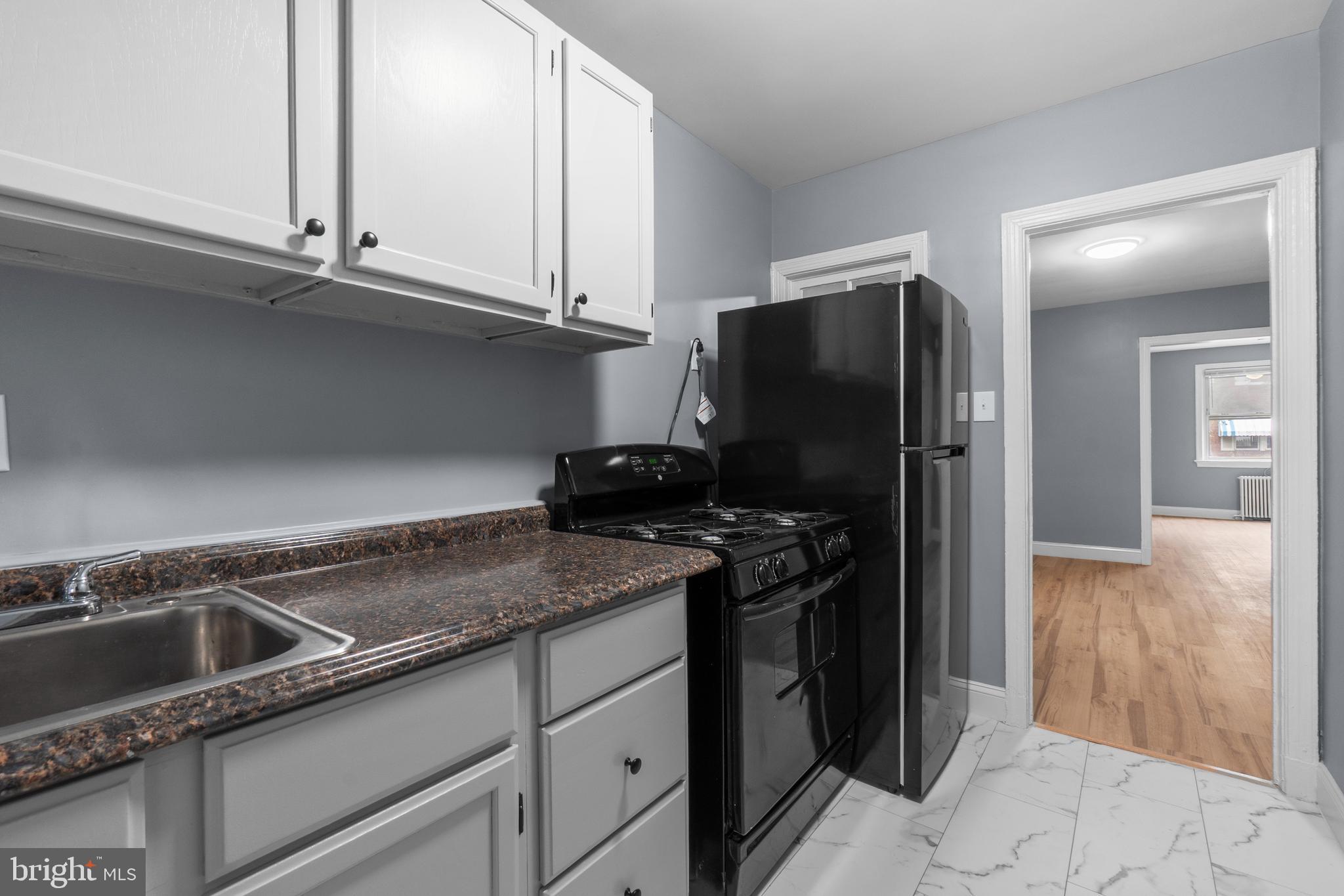 1721 29th Street Southeast, Unit 1 Washington, DC 20020 - Photo 7 of 24 a kitchen with granite countertop a refrigerator and a sink