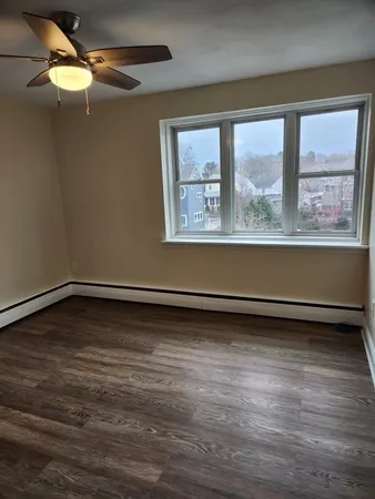 a view of a room with wooden floor and a window