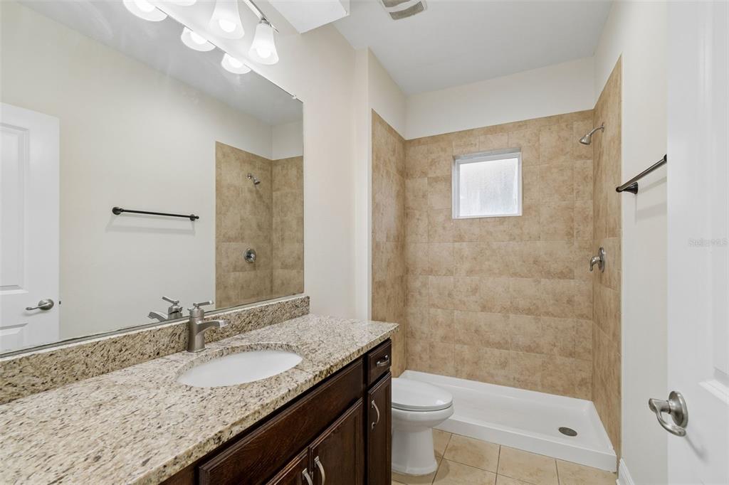 2322 West Chestnut Street Tampa, FL 33607 - Photo 11 of 27 a bathroom with a granite countertop sink a toilet and shower