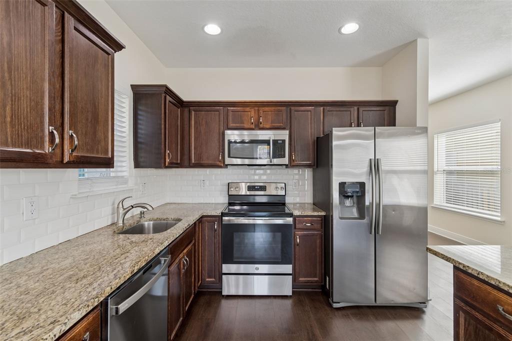 2322 West Chestnut Street Tampa, FL 33607 - Photo 8 of 27 a kitchen with granite countertop a refrigerator and a stove