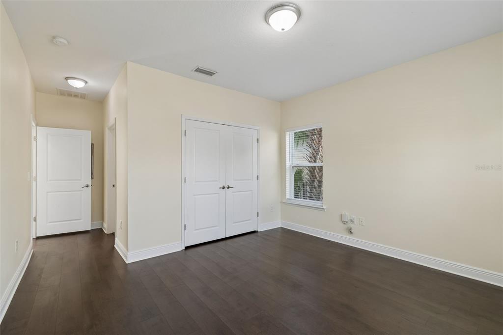 2322 West Chestnut Street Tampa, FL 33607 - Photo 9 of 27 an empty room with wooden floor and windows