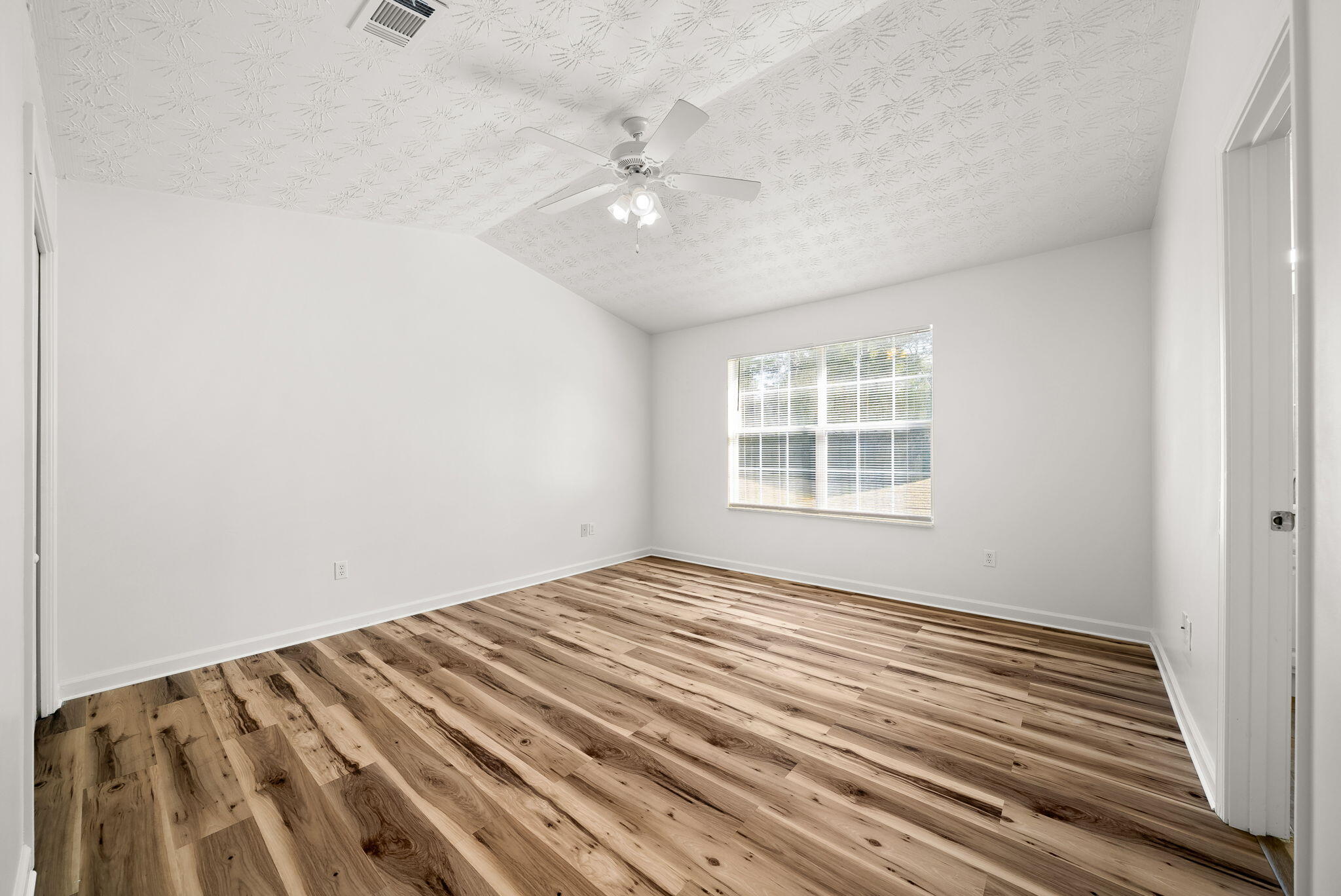 88 Tropical Way Freeport, FL 32439 - Photo 12 of 31 a view of an empty room with wooden floor and a window