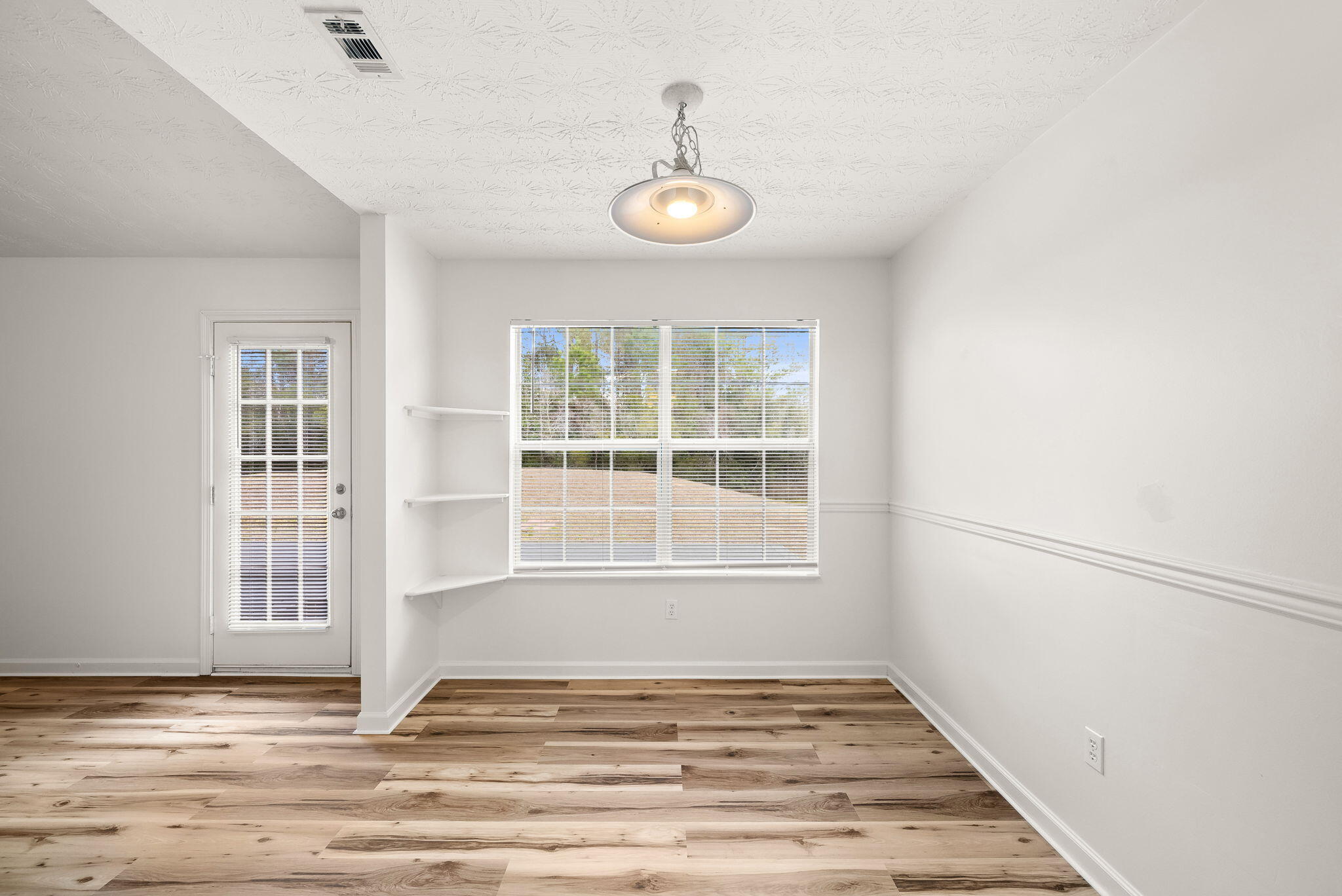 88 Tropical Way Freeport, FL 32439 - Photo 9 of 31 a view of an empty room with wooden floor and a window