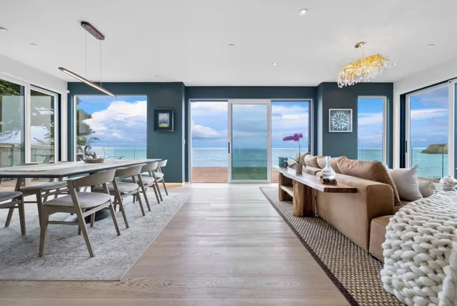 a living room with furniture tv and a floor to ceiling window