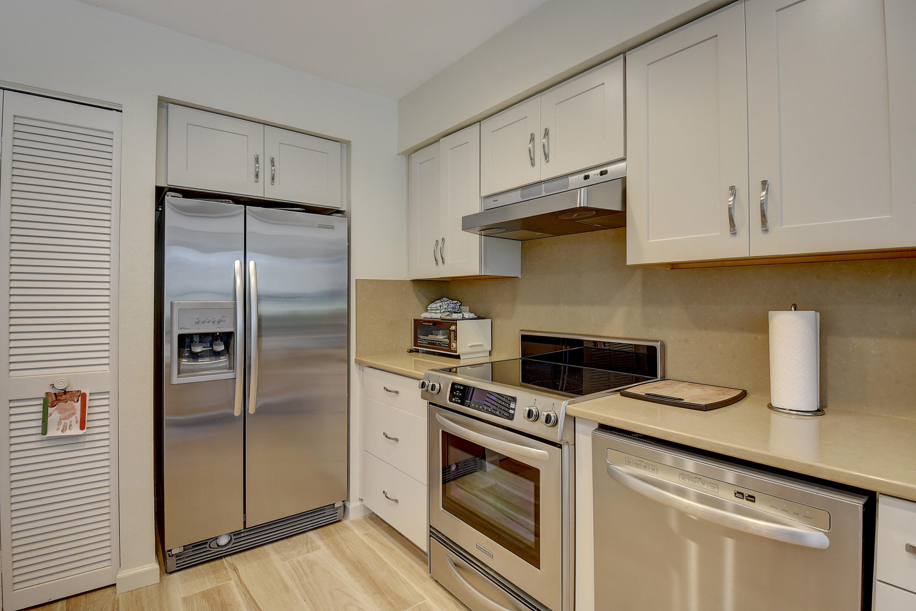 19550 Sawgrass Drive, Unit 2102 Boca Raton, FL 33434 - Photo 11 of 76 a kitchen with refrigerator a stove and cabinets