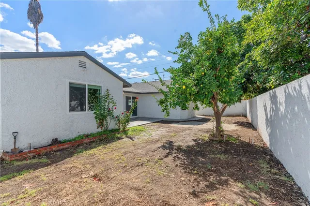 a white house with a large tree in front of it
